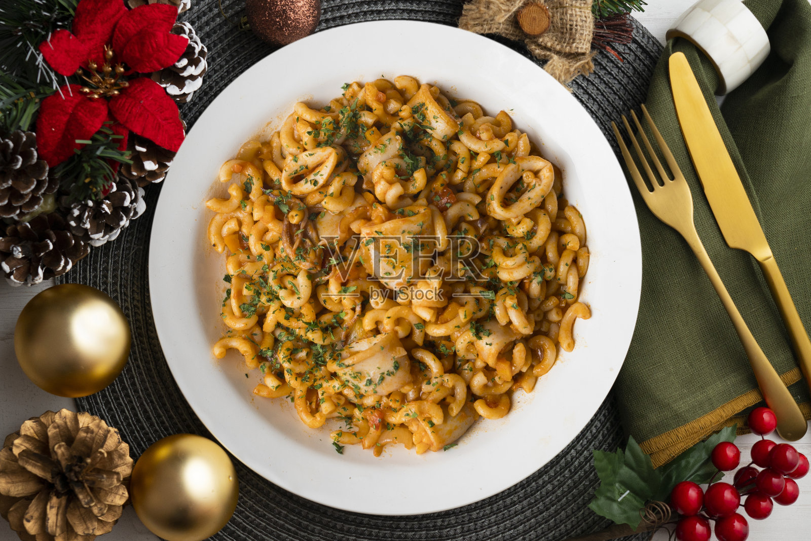 美味的西班牙菜配海鲜。典型的西班牙美食,摆上圣诞装饰的桌子。照片摄影图片