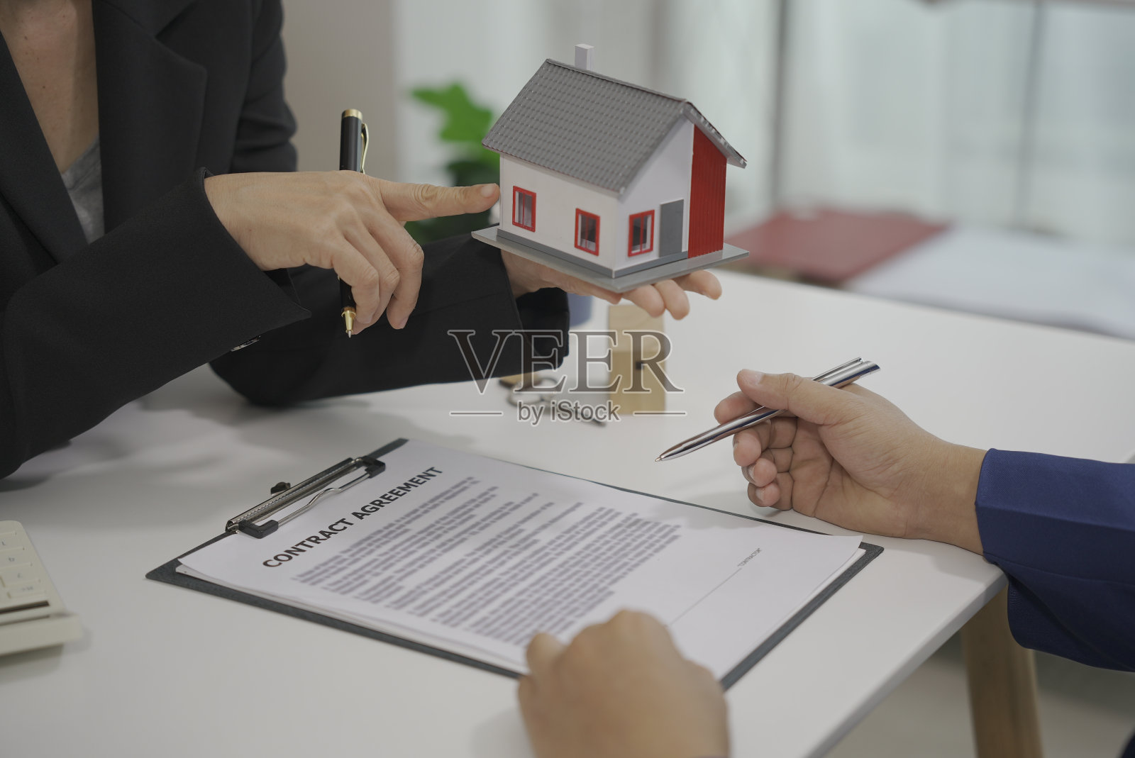 客户和员工通过看材料来讨论材料。签订房屋买卖合同、房屋租赁合同、财产保险照片摄影图片