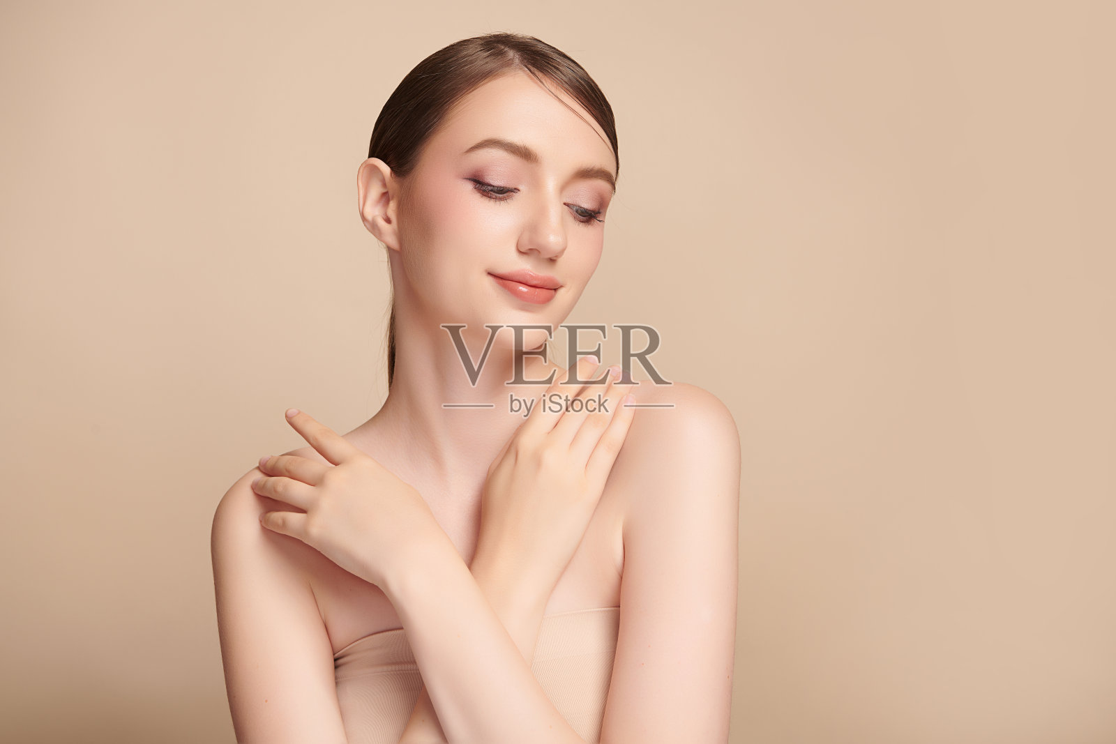 美丽的年轻女子干净新鲜的皮肤在米色背景,面部护理,面部治疗,美容,美容和水疗,女性肖像。照片摄影图片