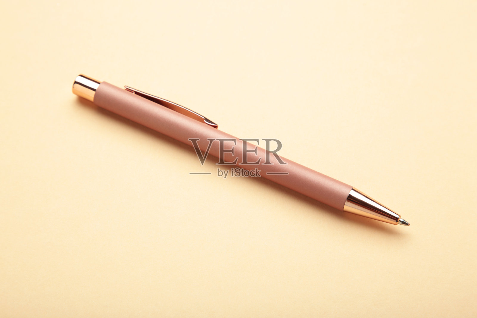 米色背景上的新时尚米色钢笔。俯视图照片摄影图片