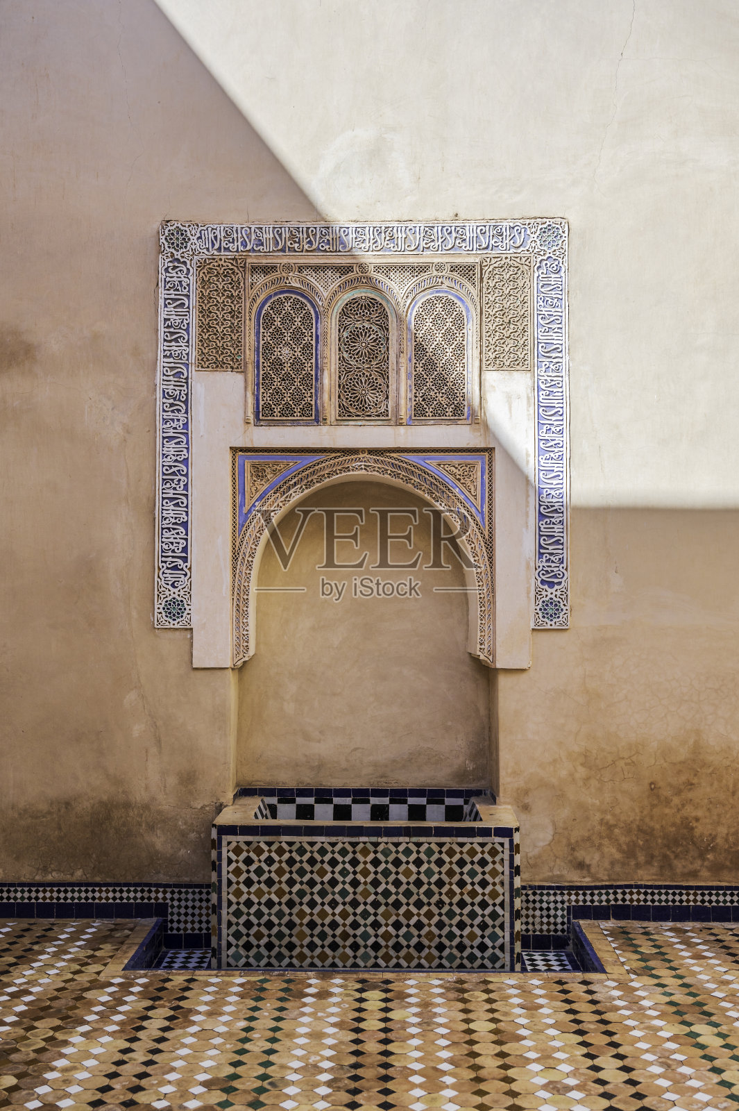 马拉喀什的典型喷泉。这口井嵌在一面赭石色的墙上照片摄影图片