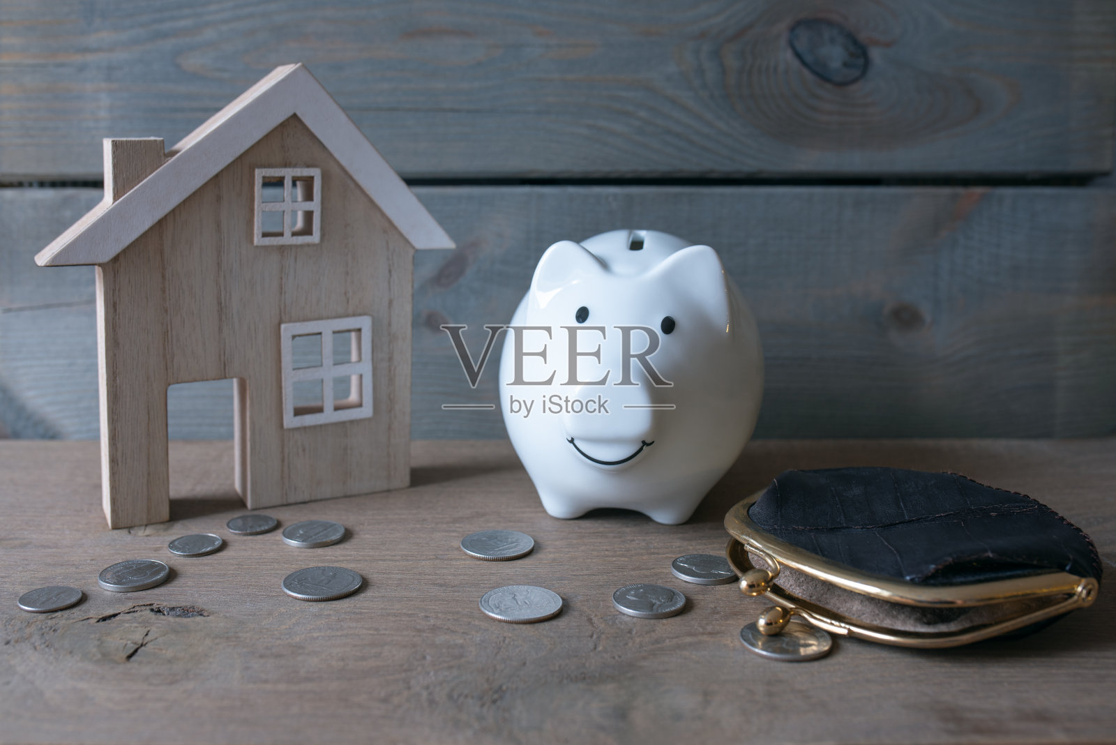 储钱罐,旧钱包和房子模型在木桌与复制空间。金融和房地产的概念。照片摄影图片