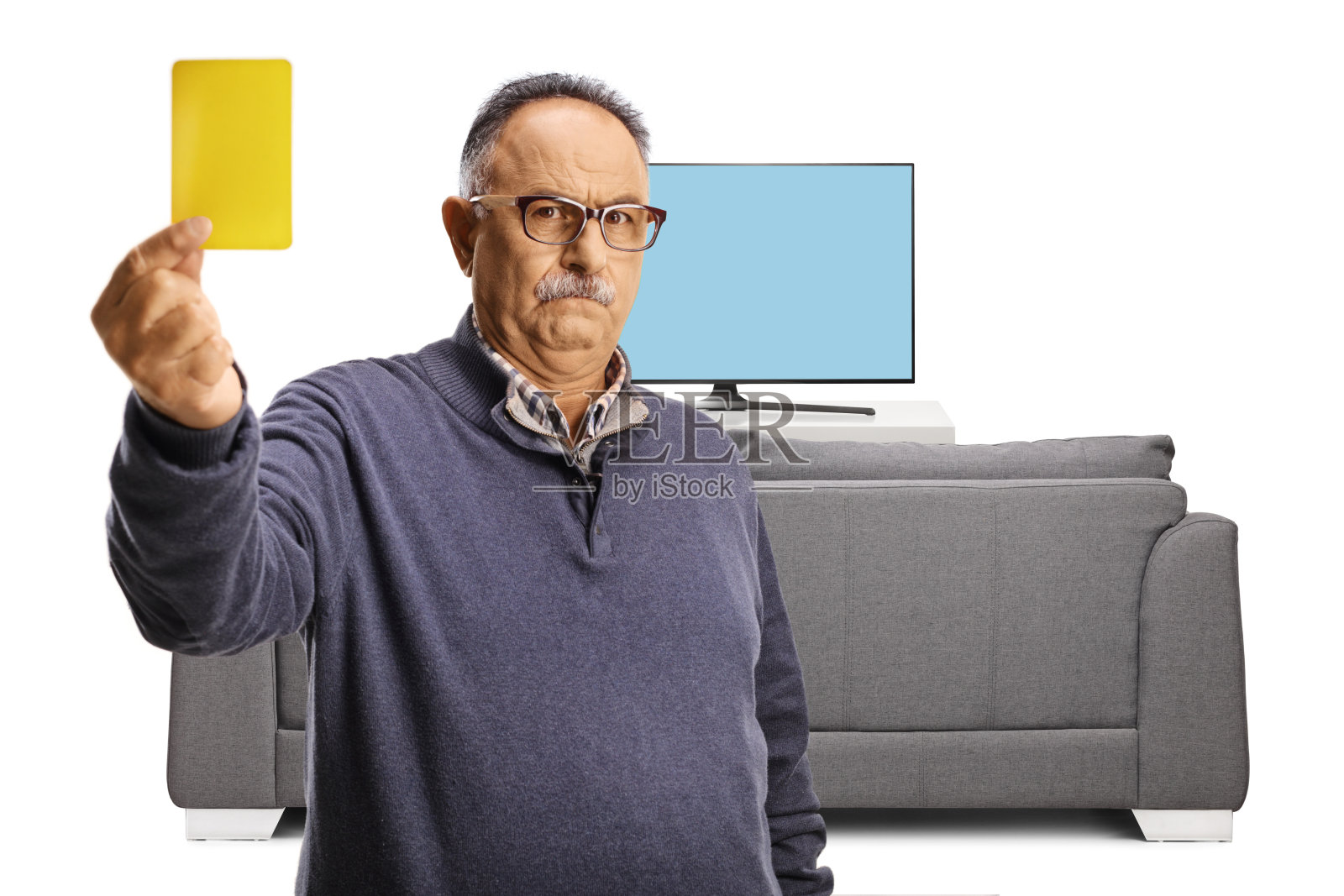 严肃的中年男人在电视屏幕前出示黄牌照片摄影图片
