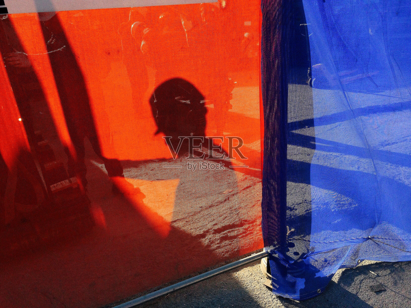 工地上红色纺织品上工人的影子照片摄影图片