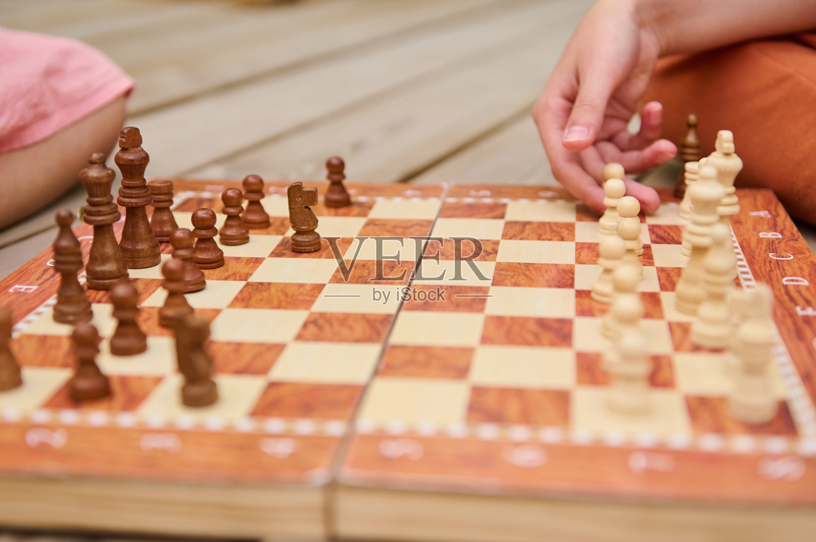 背景模糊的木板上正在进行的象棋比赛的特写照片摄影图片