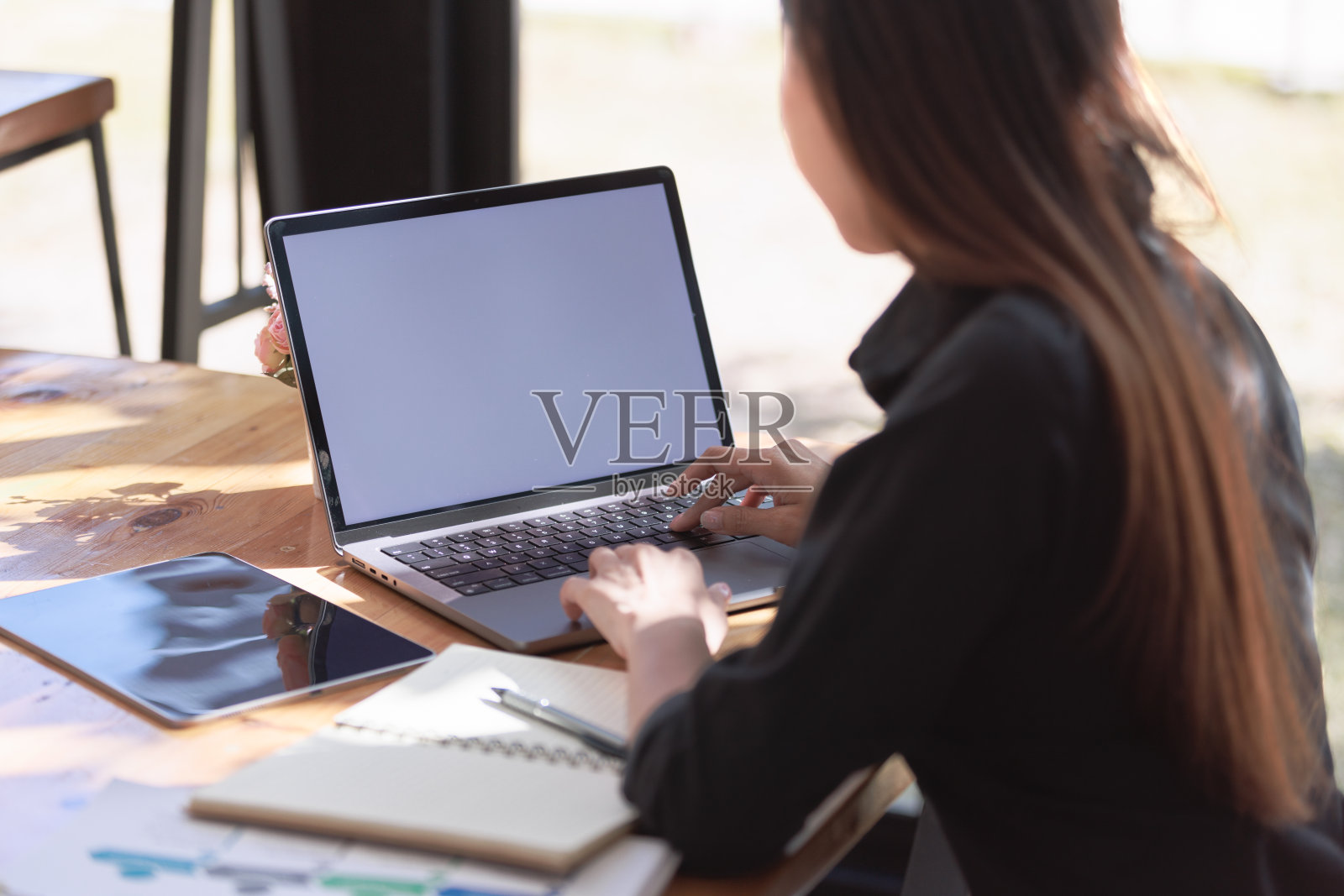 美丽的年轻女子在工作空间与智能手机和笔记本电脑照片摄影图片