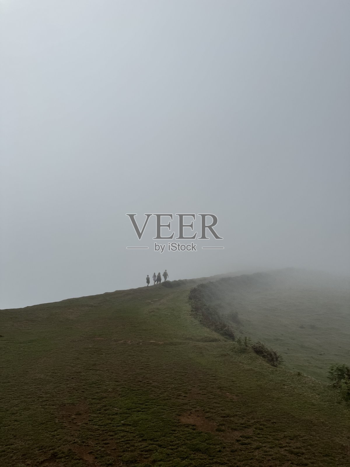 人们在雾中走在山上照片摄影图片