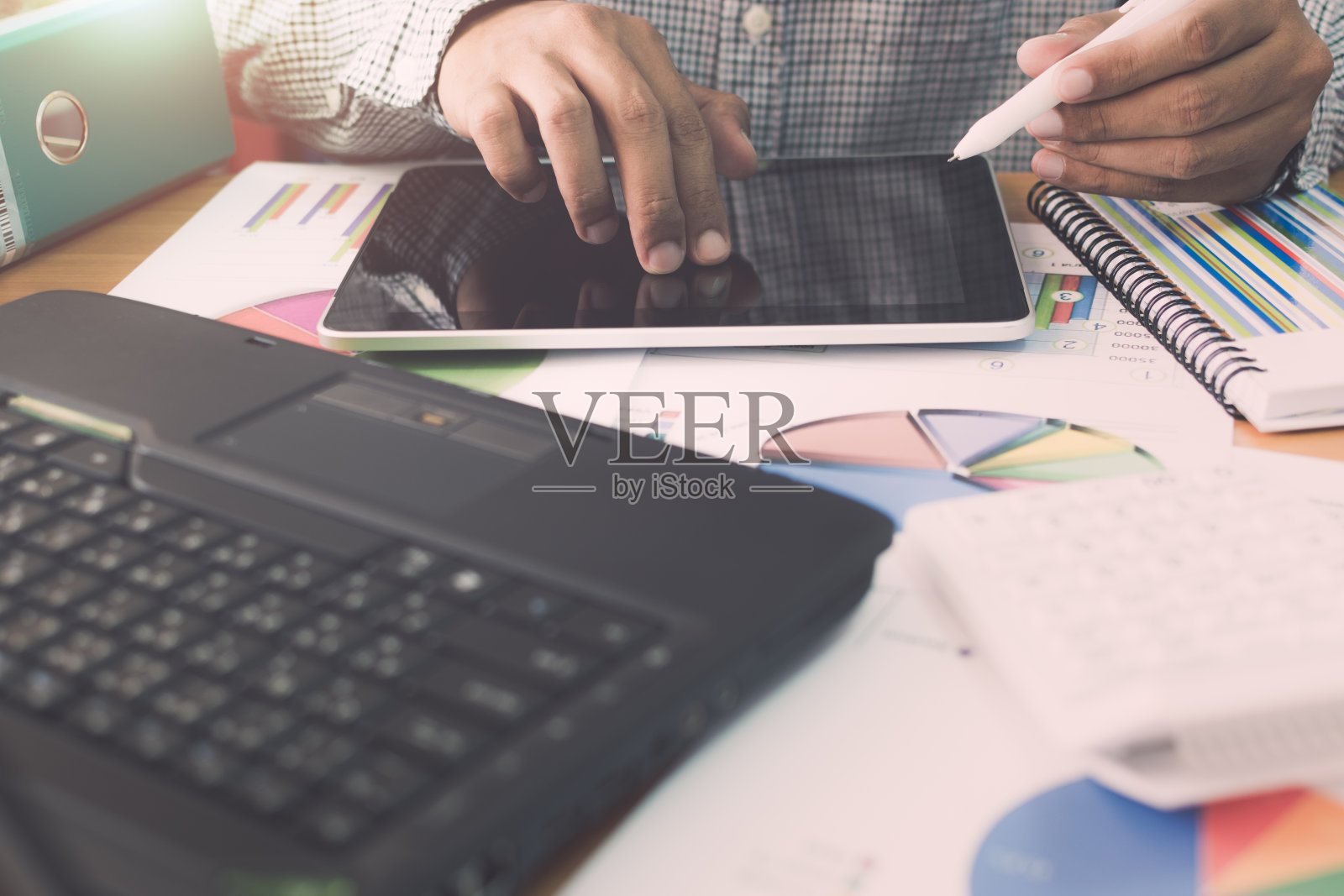 商人在平板电脑上工作与营销信息图表在办公室。照片摄影图片