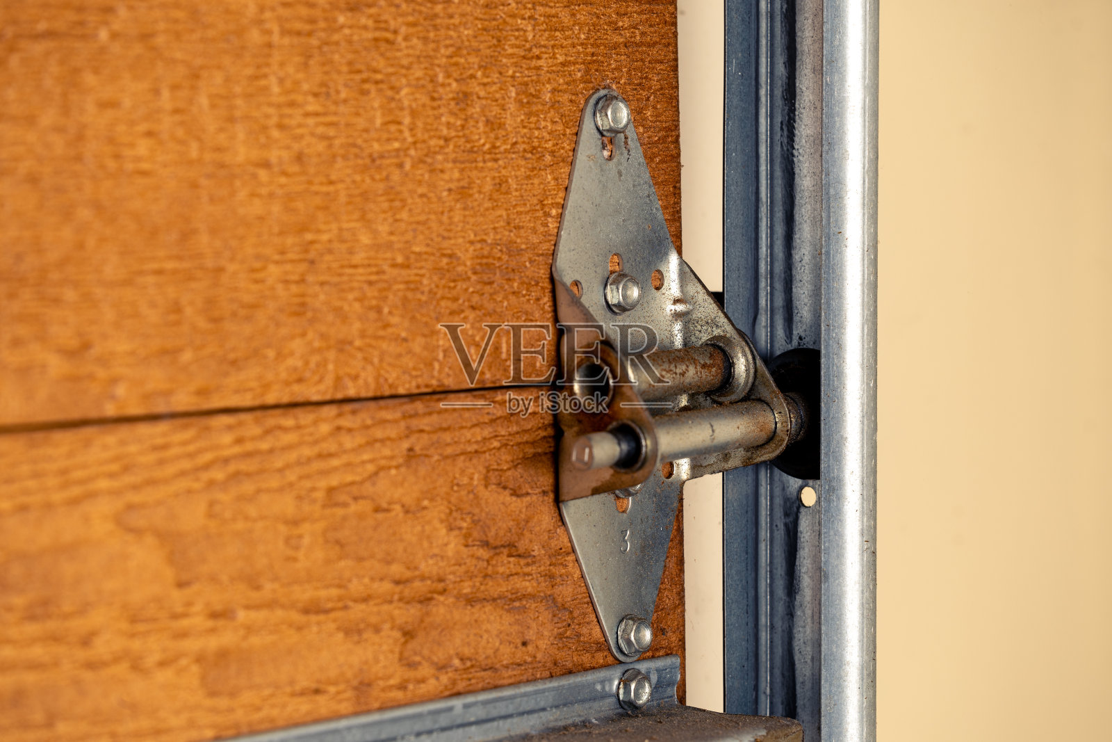 车库门铰链和滚轮在木门上的闭合,选择性聚焦。照片摄影图片