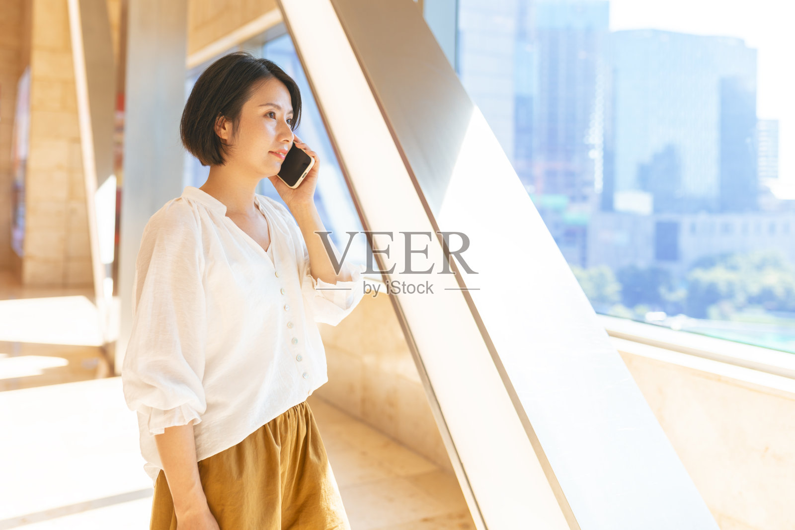 亚洲妇女在窗边使用手机照片摄影图片