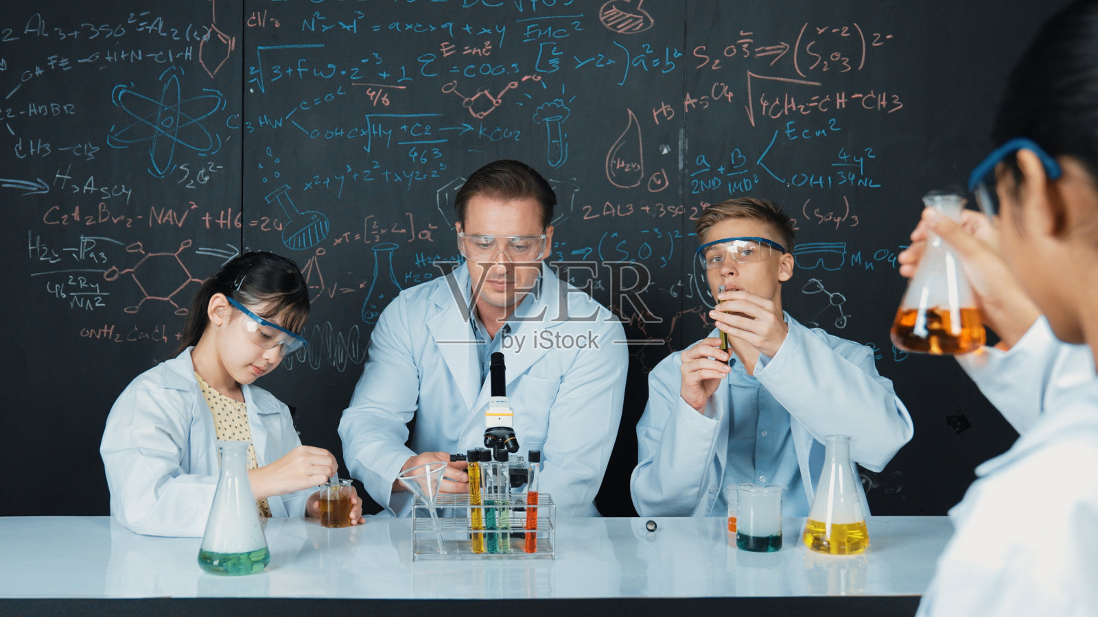 老师讲解化学理论,学生混合溶液。启迪。照片摄影图片