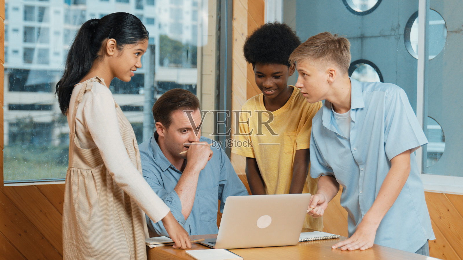 一个高中男孩在老师看笔记本电脑的时候展示项目。启迪。照片摄影图片