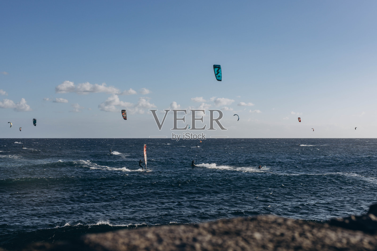 男子专业冲浪者站在沙滩上与他的风筝和板。风帆冲浪,极限运动照片摄影图片