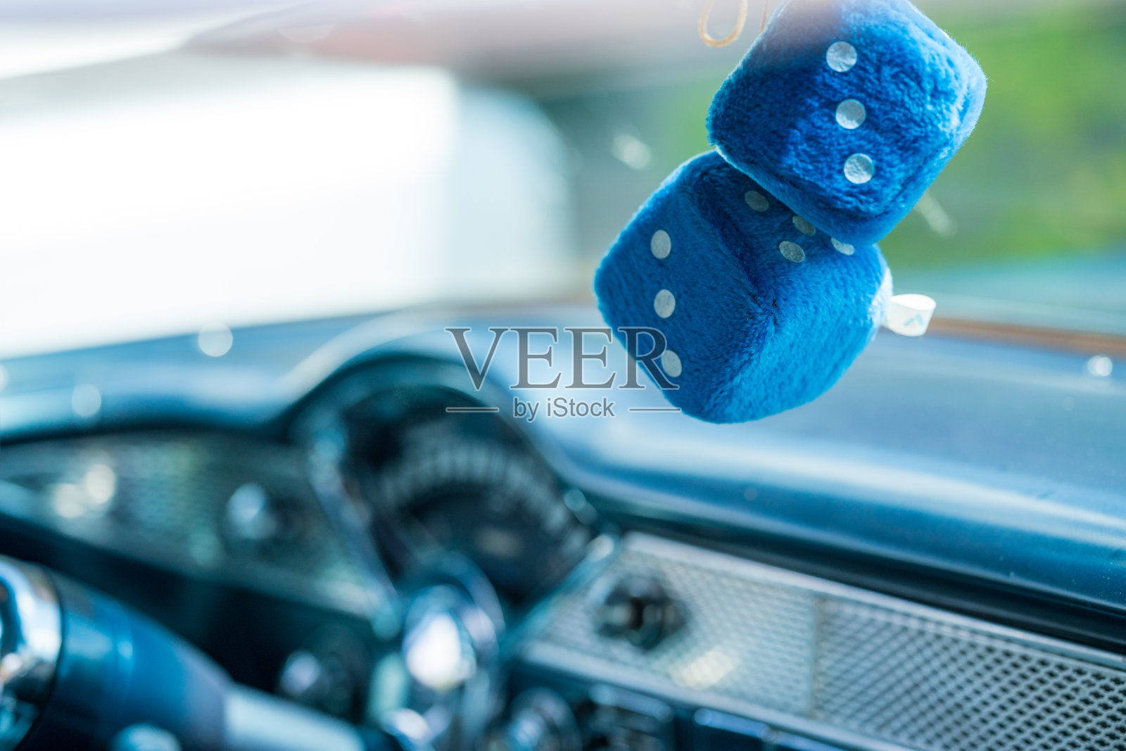 挂在挡风玻璃上的骰子特写照片摄影图片