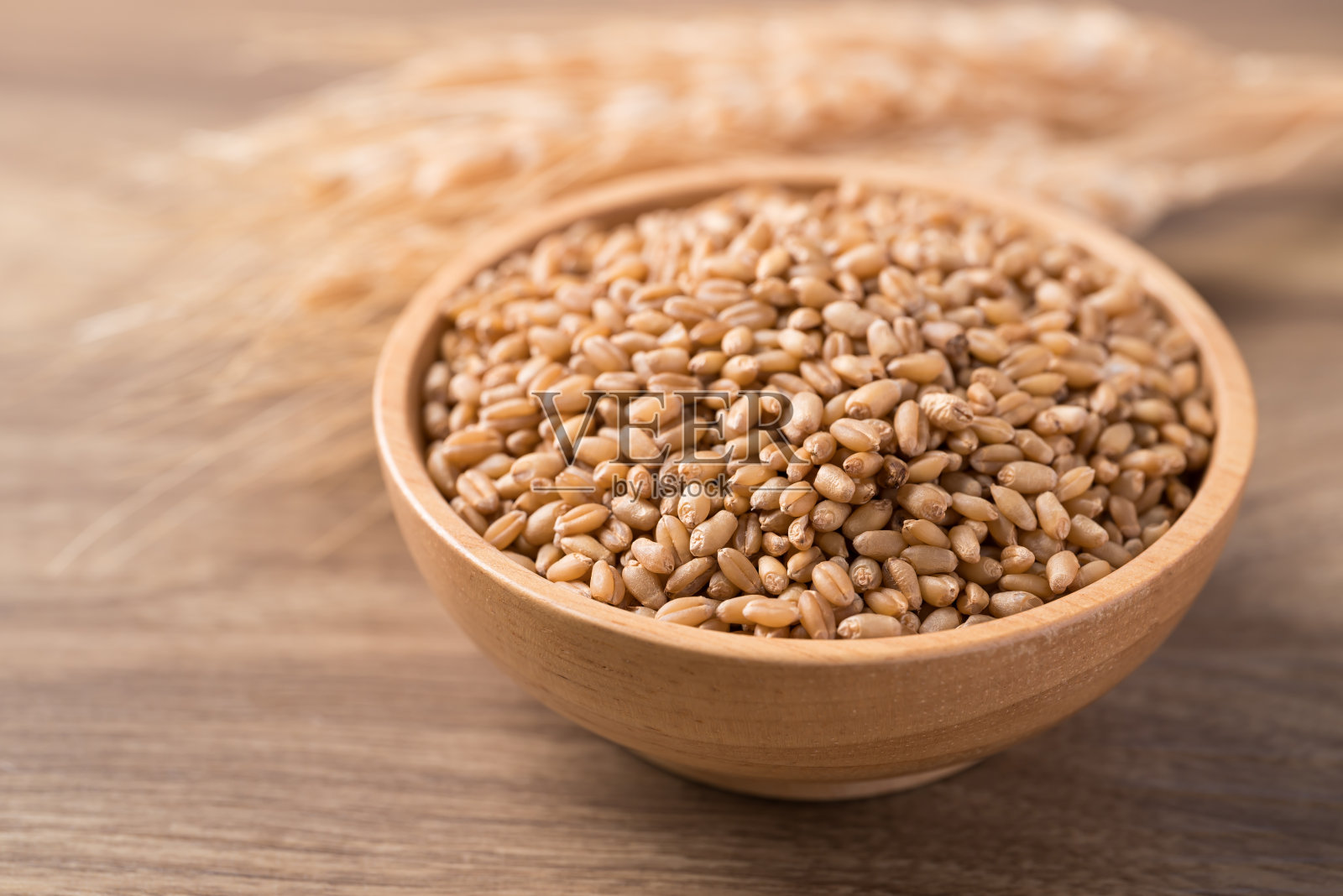 木质背景木碗里的全麦谷物,食品配料照片摄影图片