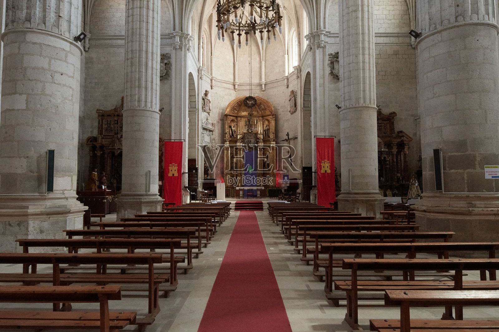 一座历史悠久的教堂内部,有石柱和木制长椅照片摄影图片