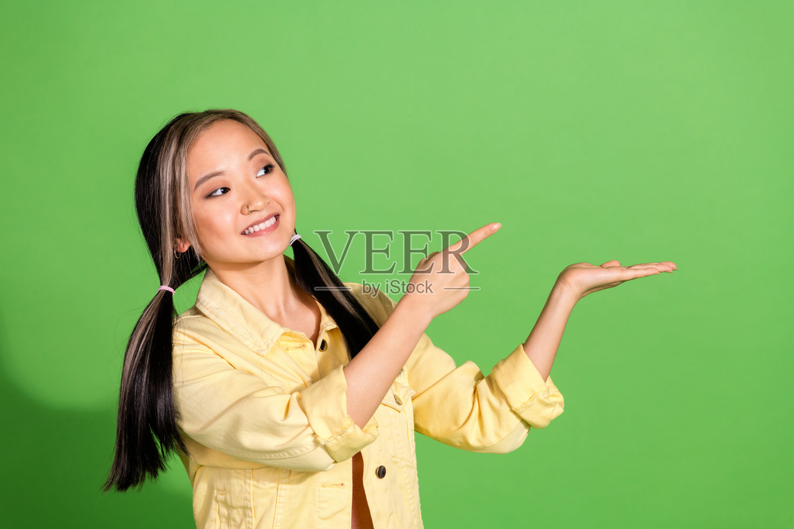 漂亮的年轻女孩的照片直接看手指握空空间穿夹克孤立的绿色背景照片摄影图片