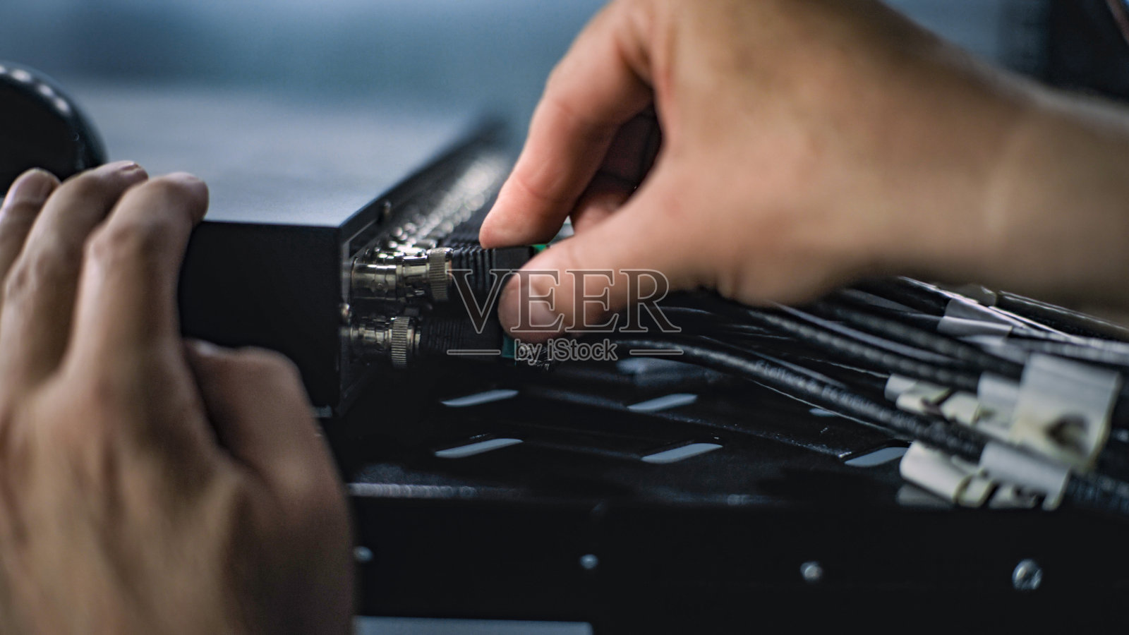 男网络管理员将电缆插入服务器机架的特写照片摄影图片