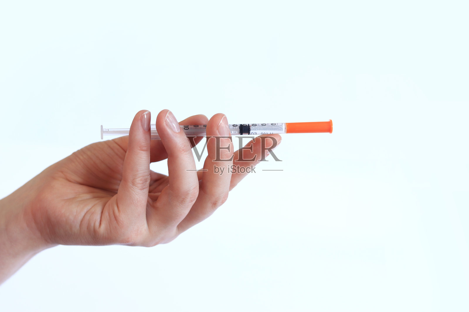胰岛素注射器。一个女人手里拿着一个注射器,背景是白色的照片摄影图片