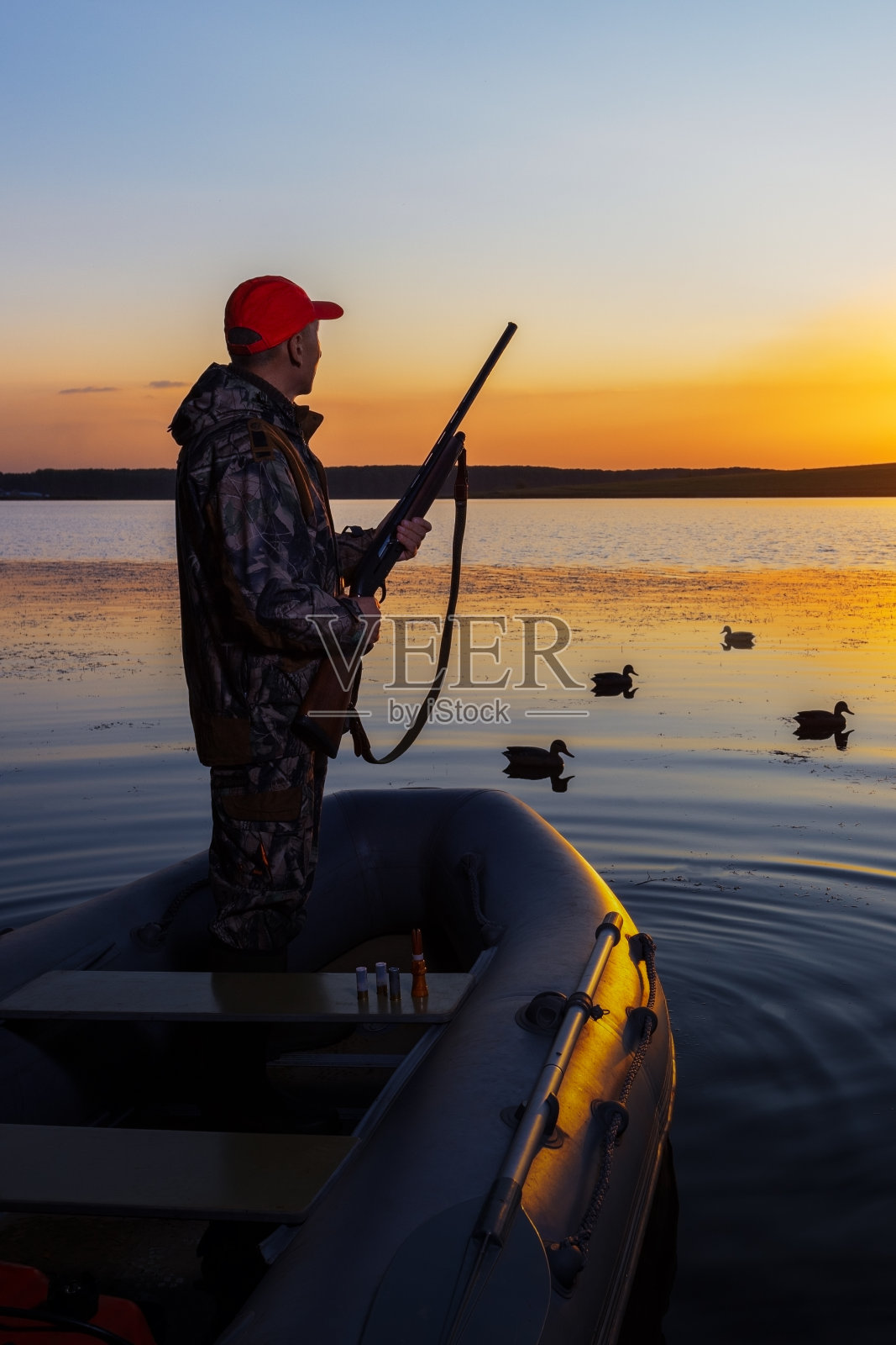 水禽猎人看着鸭子。有人在湖边打猎。照片摄影图片