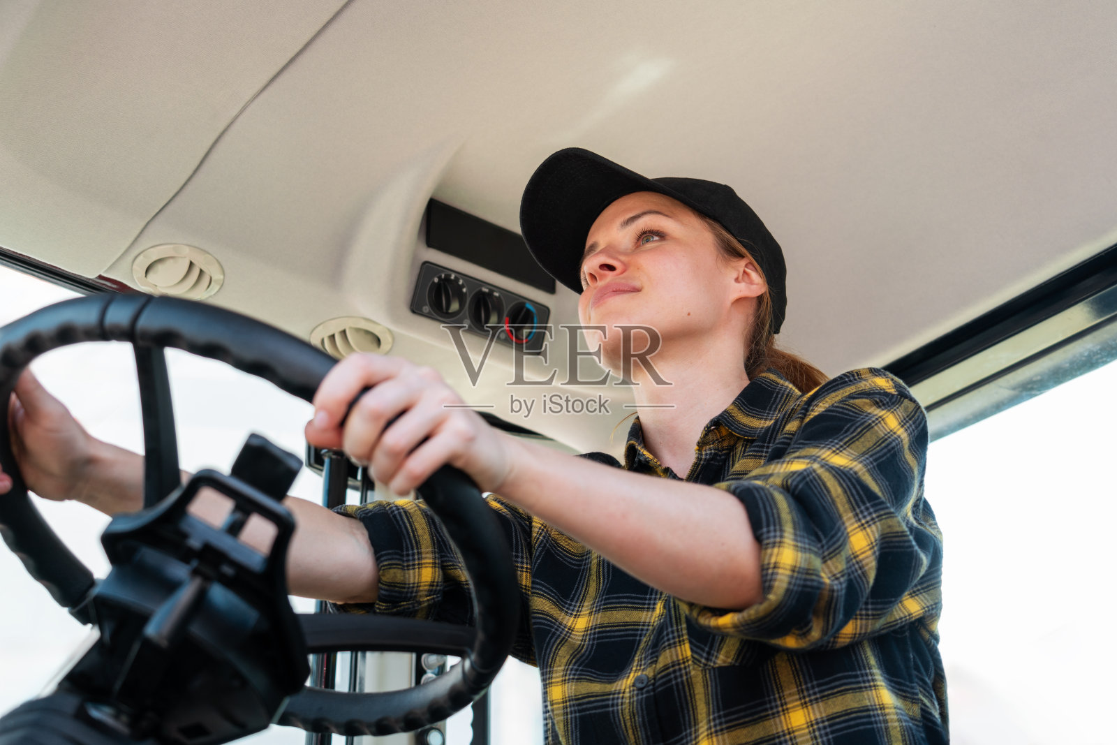 年轻成年女性驾驶农用拖拉机。照片摄影图片