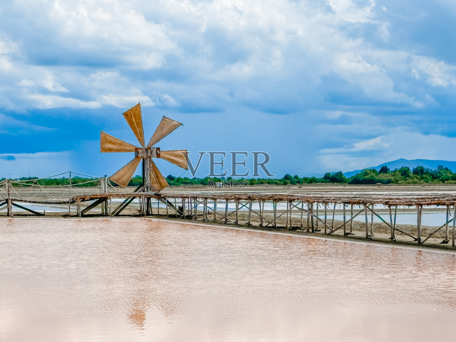 蓝天下盐田里的木制风车照片摄影图片