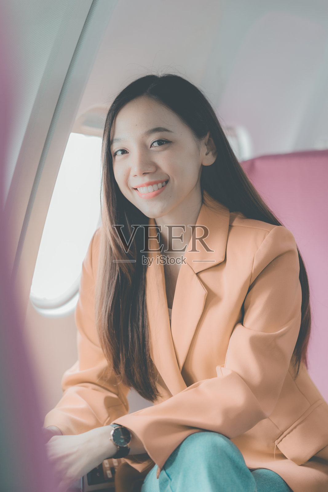 一位独自乘坐飞机旅行的年轻亚洲女游客在飞机上望向窗外。独自旅行概念照片摄影图片