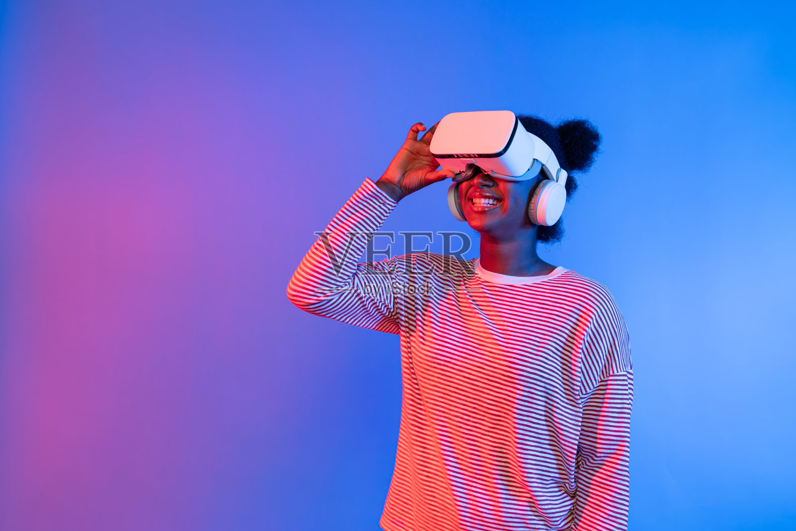 微笑的非洲年轻女子戴着VR头显令人惊讶。发明。照片摄影图片