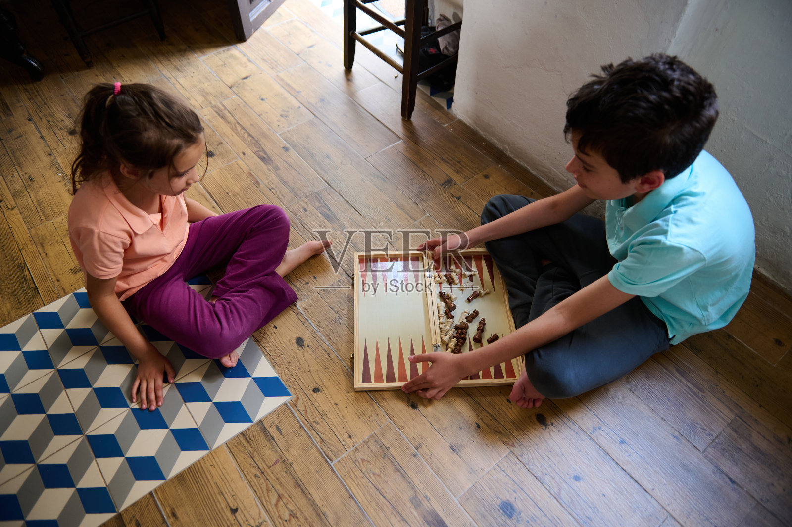 孩子们在室内木地板上一起玩西洋双陆棋照片摄影图片