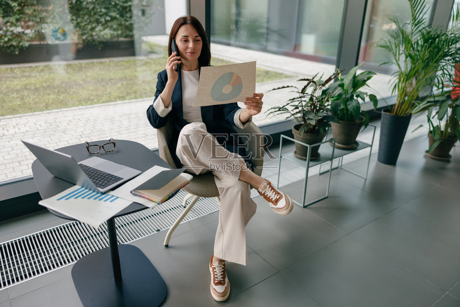 一位自信的女商人正在一间现代化的办公室里用笔记本电脑和图表分析数据照片摄影图片