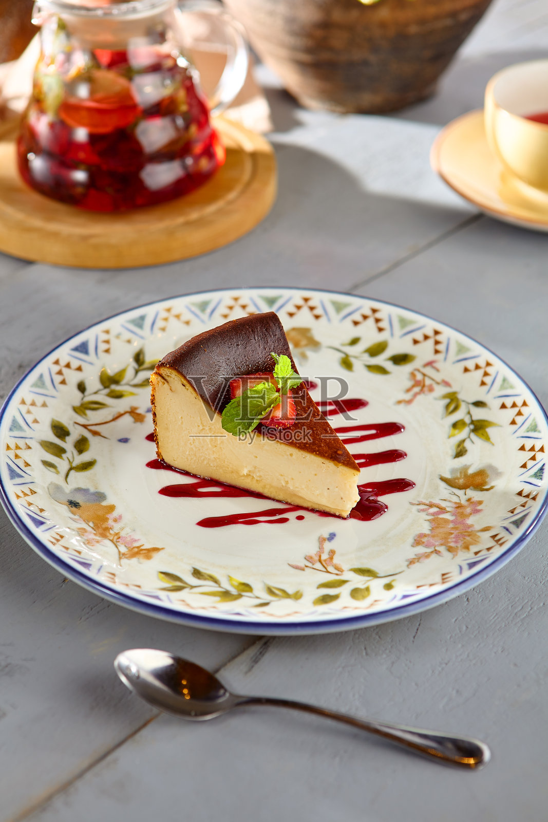 一片正宗的巴斯克芝士蛋糕,配上浆果和薄荷装饰盘照片摄影图片