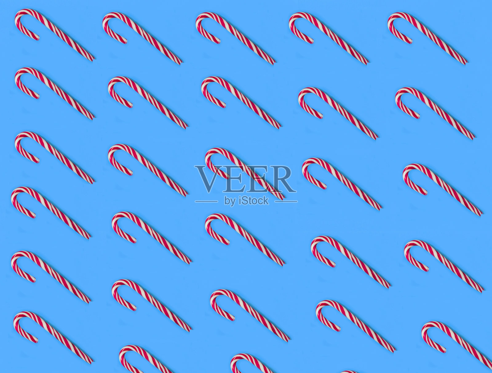 圣诞节的背景。蓝色背景上的硬糖棒。平的。照片摄影图片