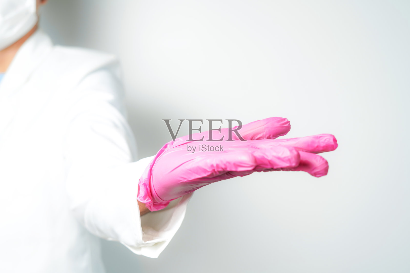 医生或护士将无菌手套放在隔离的白布上照片摄影图片