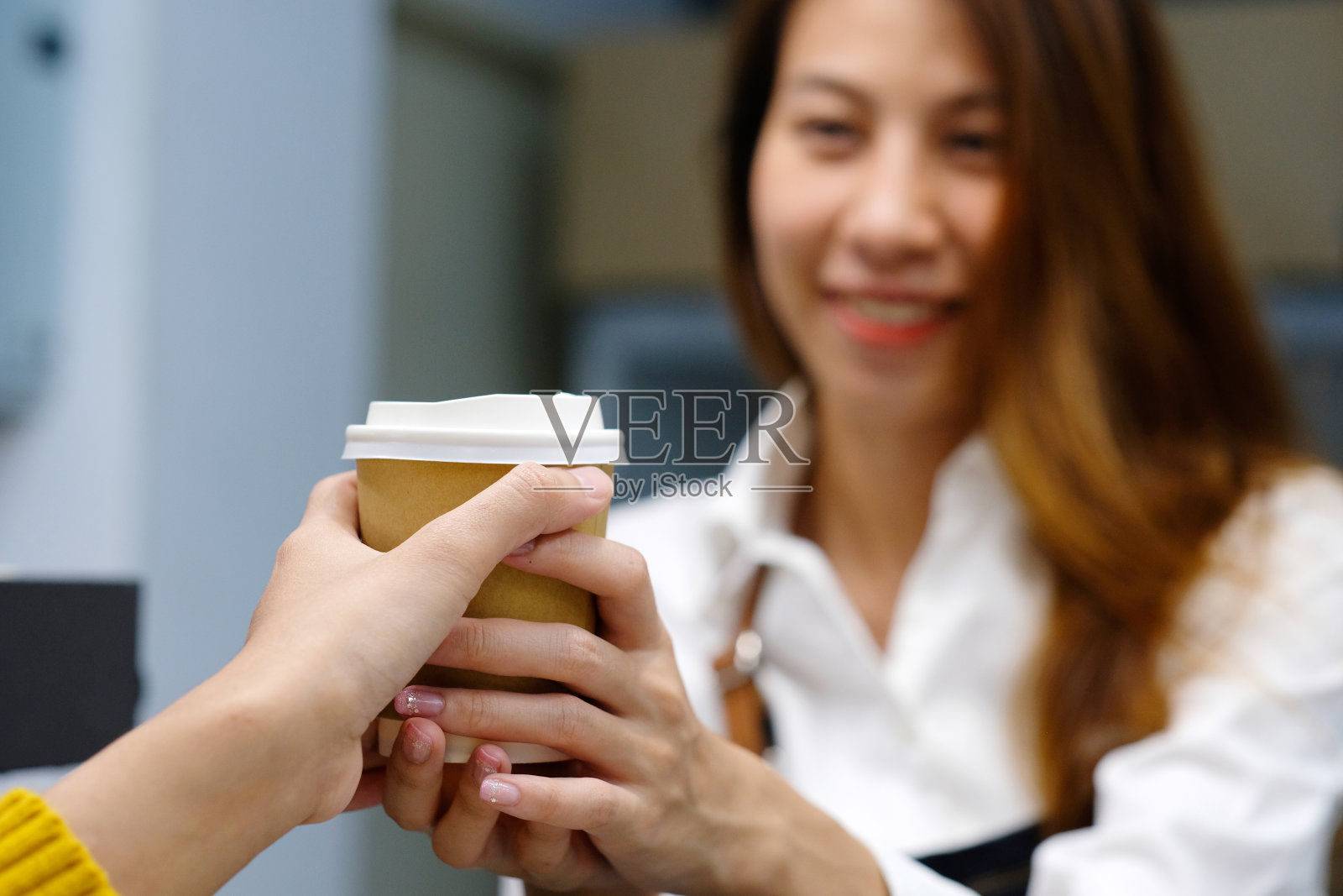 在咖啡店为顾客服务的年轻女子照片摄影图片