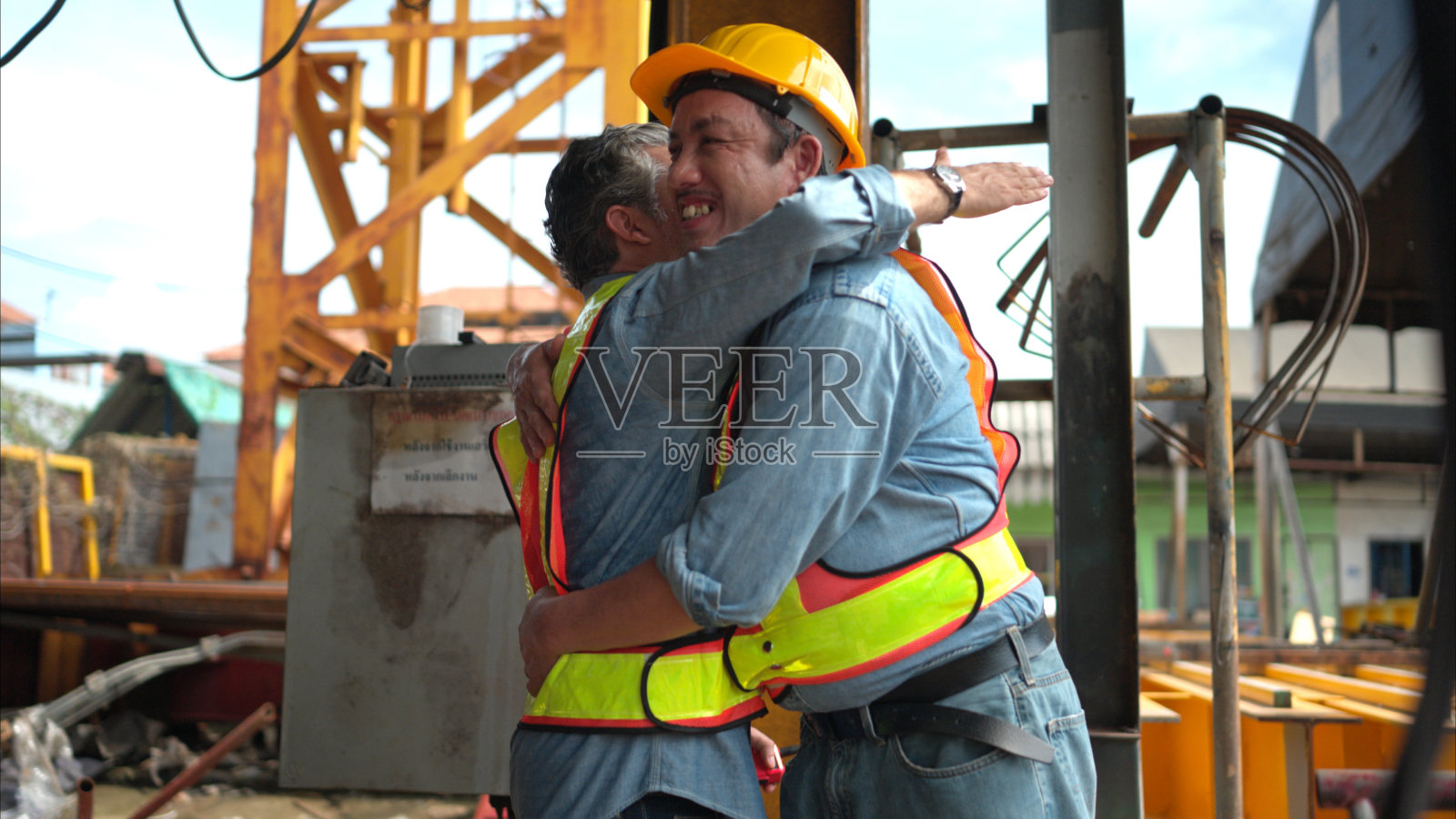 建筑工地上的两个工人在开始一天的工作前互相问候照片摄影图片