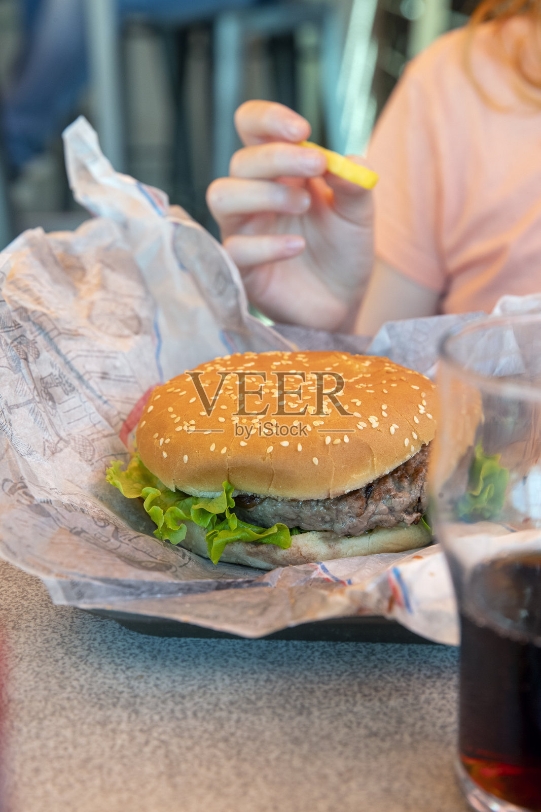 从高角度拍摄的放在纸巾上的汉堡,放在餐馆的托盘上。照片摄影图片