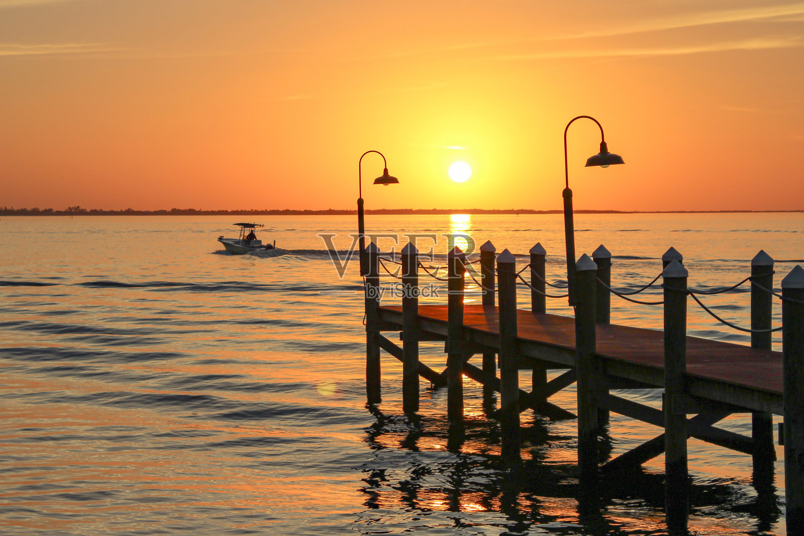 剪影喷射在沙滩上与橙色的天空与船照片摄影图片