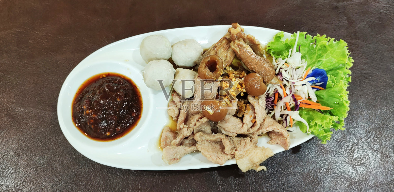 盛在盘子里的煮肉蘸酱照片摄影图片