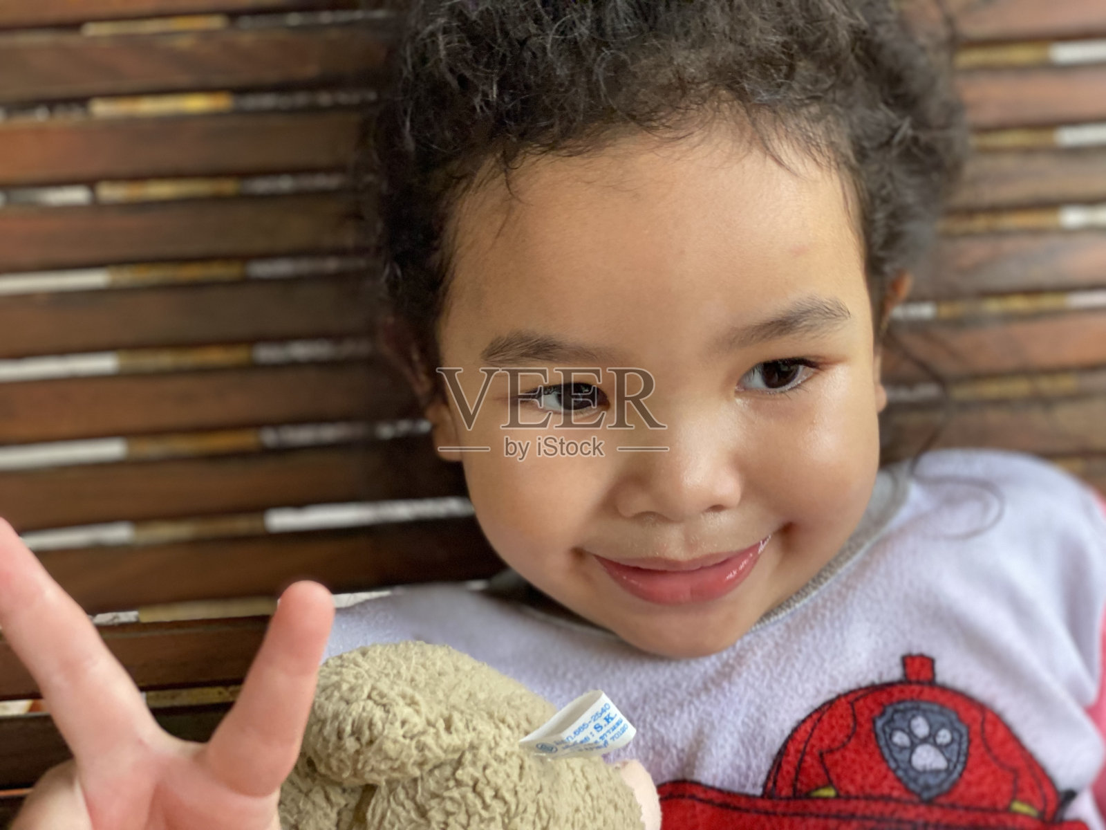 亚洲小女孩在玩羊娃娃照片摄影图片