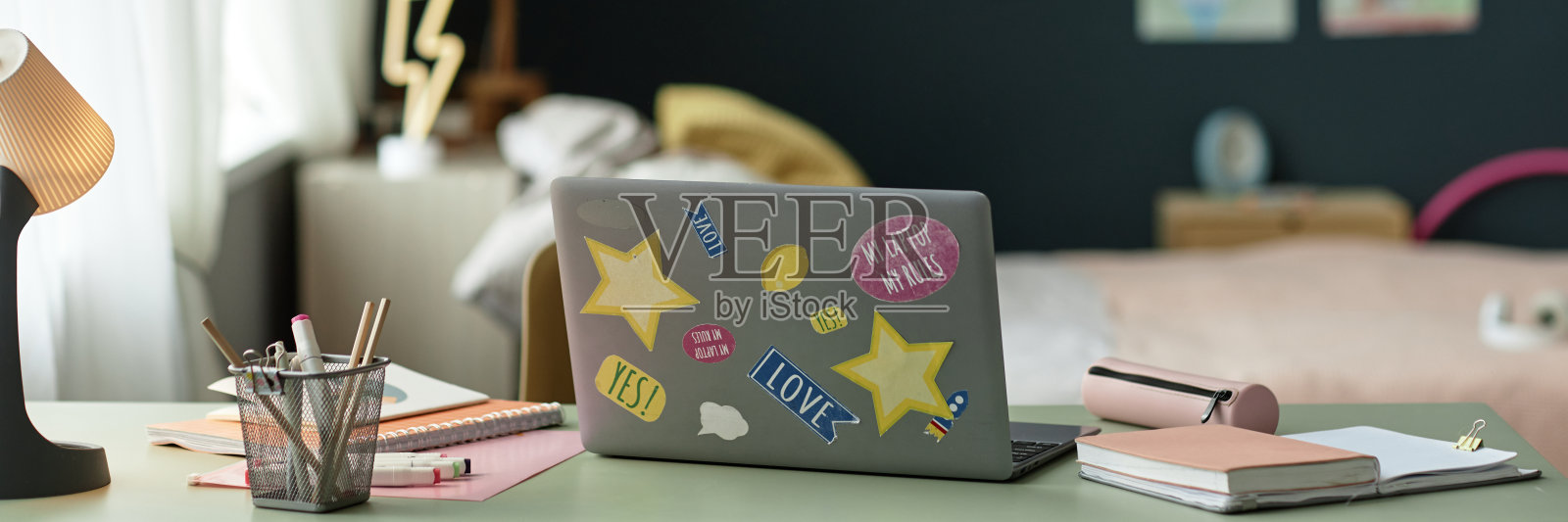 打开笔记本电脑,在儿童室的桌子上贴贴纸照片摄影图片