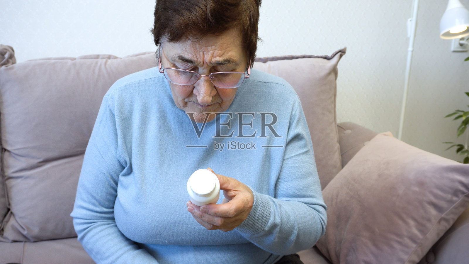 阅读药物标签的老年妇女照片摄影图片