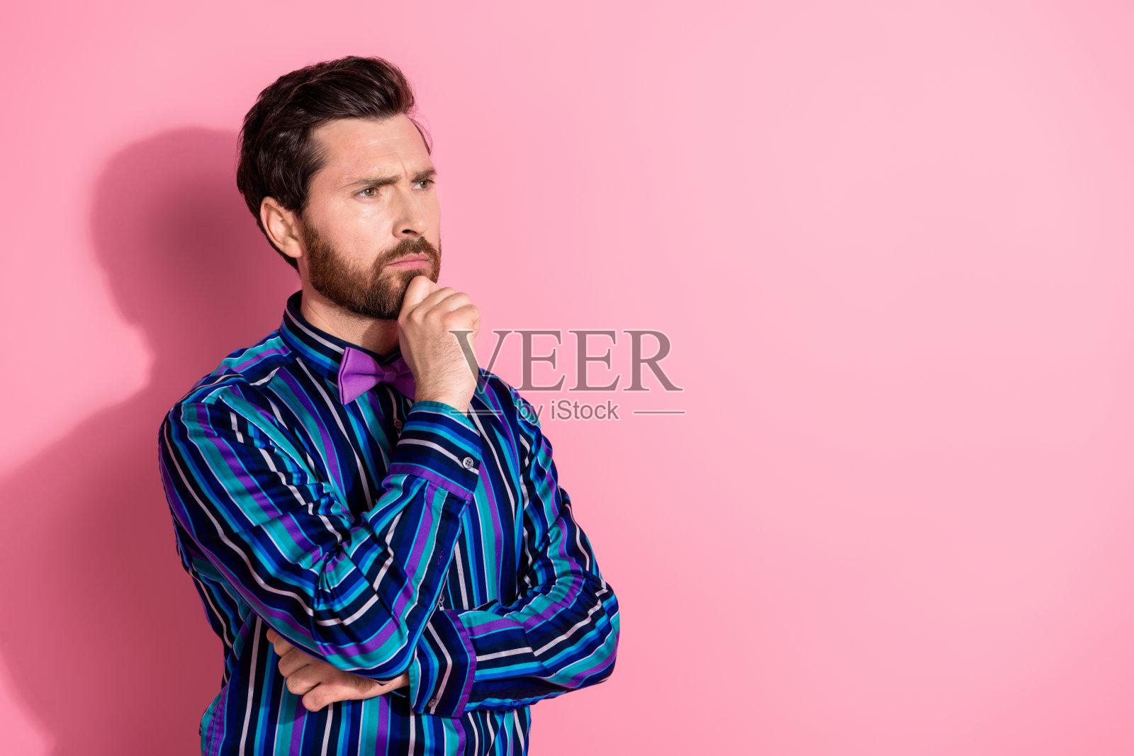 漂亮优雅的年轻人的肖像看起来空的空间穿衬衫孤立在粉红色的背景照片摄影图片