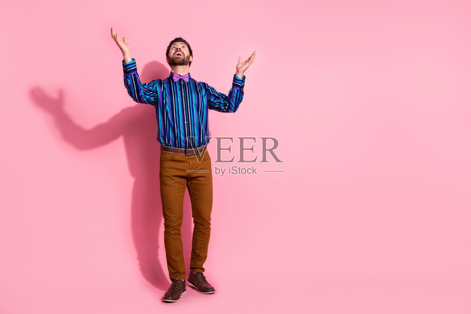 有吸引力的开朗整洁的男人穿着时髦的衣服的全身照片,在粉红色的背景上孤立的空间照片摄影图片