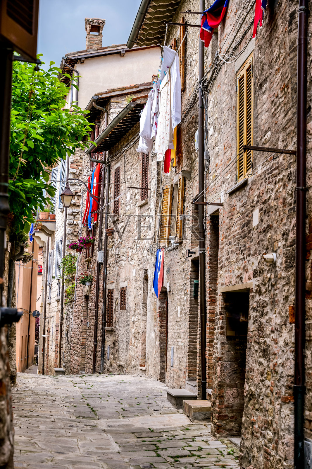 翁布里亚古比奥的中世纪小巷的美丽一瞥,衣服挂在外面晾干照片摄影图片