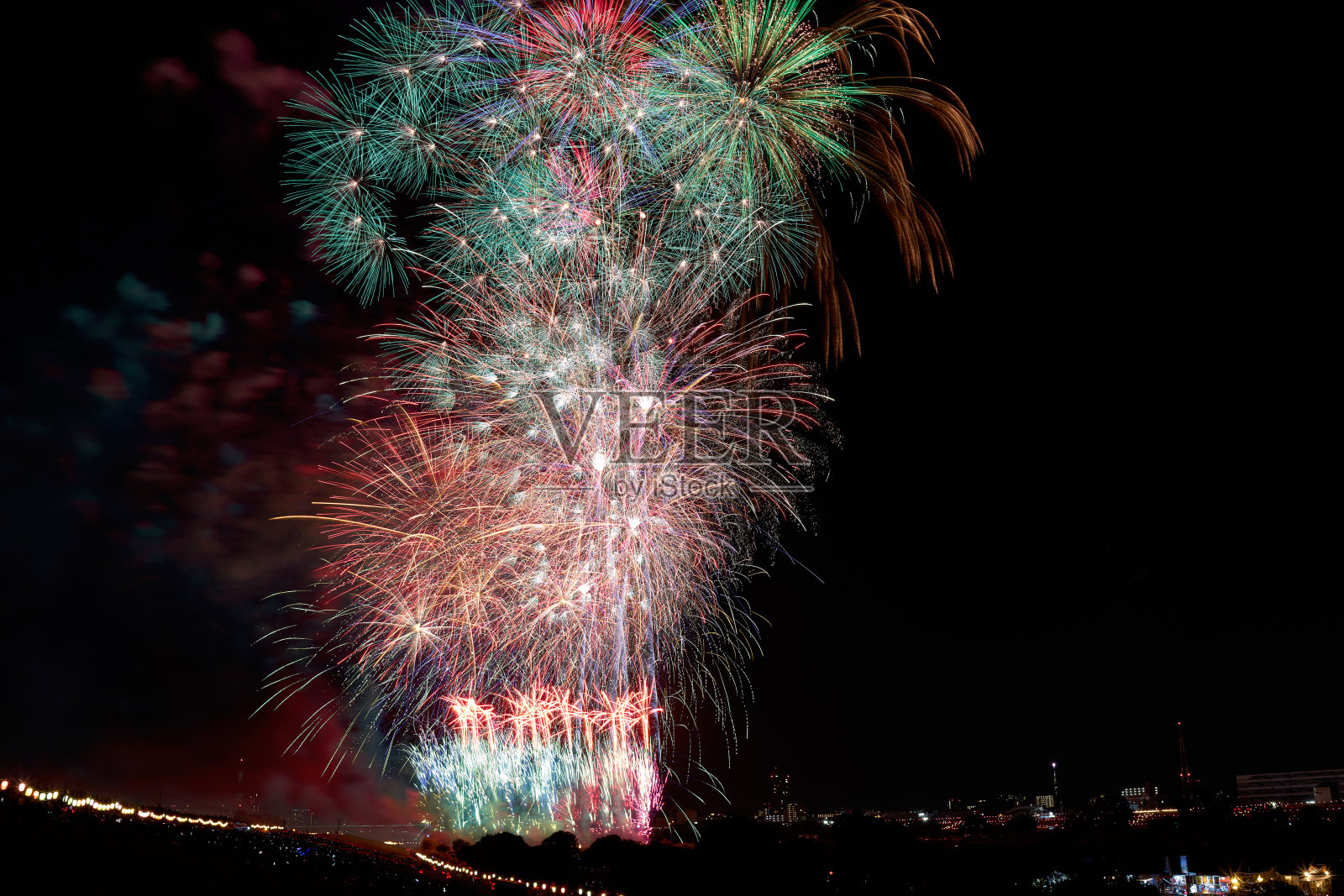 在夜空的映衬下,五颜六色的烟花。照片摄影图片