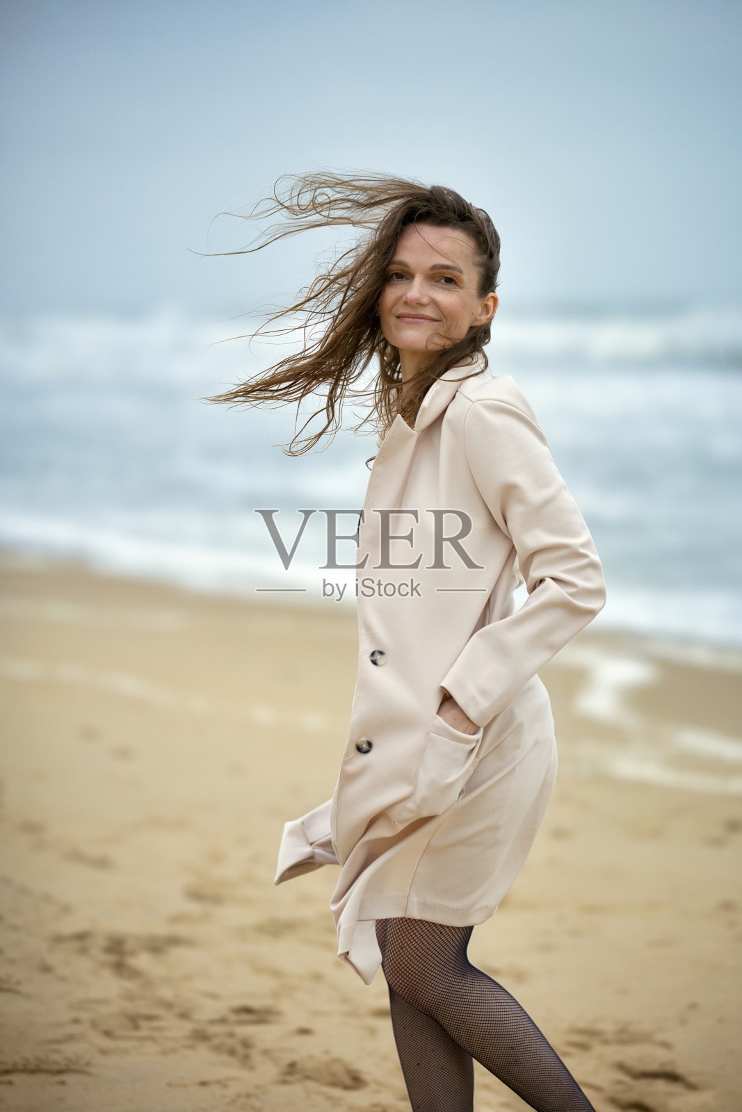 年轻女人独自在海边沙滩放松照片摄影图片