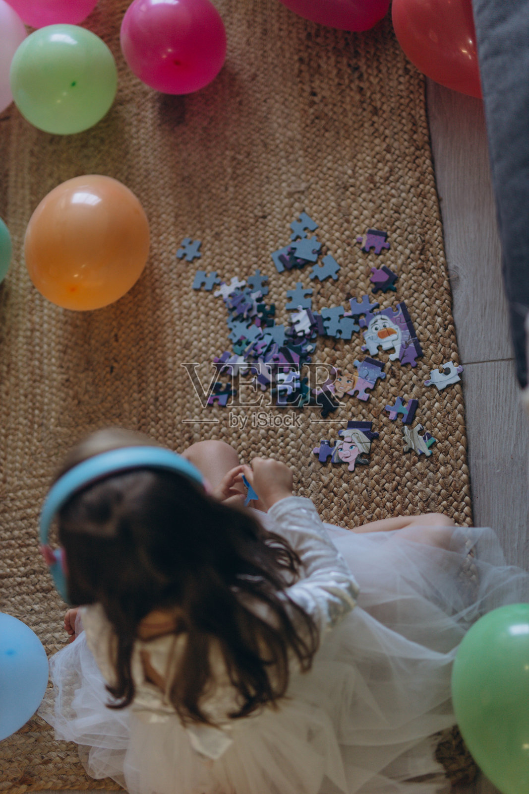 我5岁女儿的生日。她戴着耳机听音乐,收集拼图。有很多气球。照片摄影图片