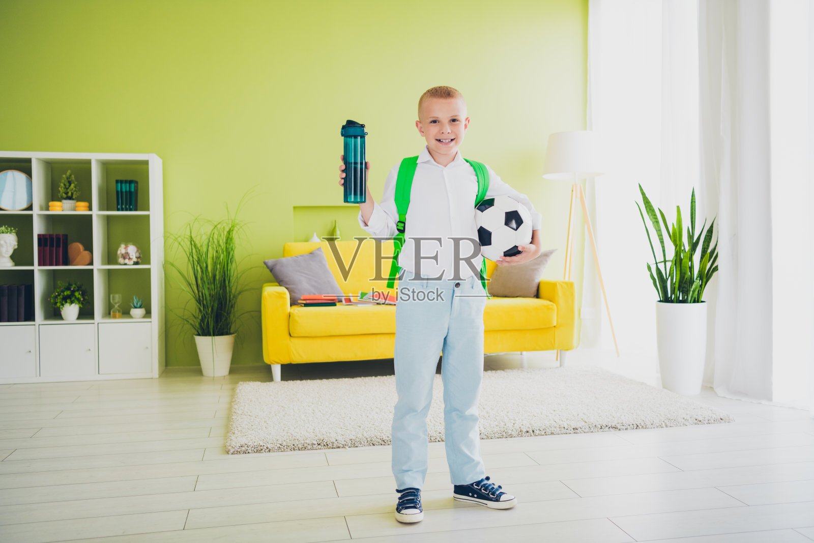 可爱的青春期前男生全身照片踢足球水瓶健康家庭教育概念学校内部照片摄影图片