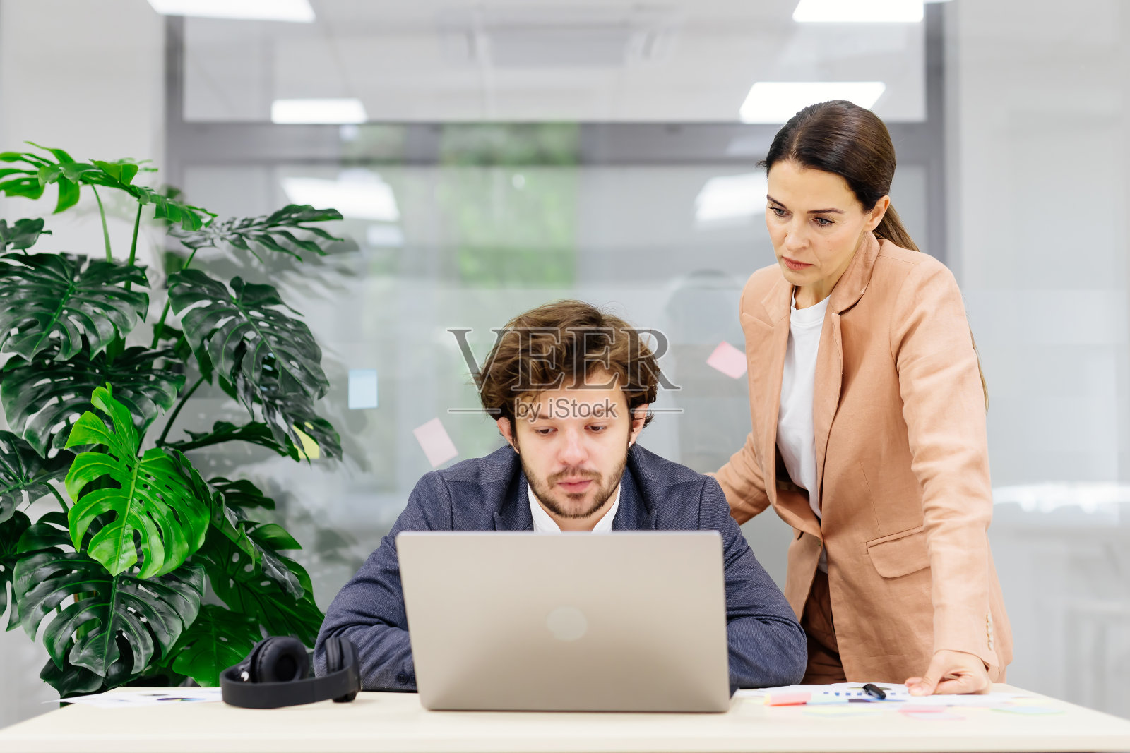 现代办公室的业务团队使用笔记本电脑进行财务分析。他们头脑风暴,讨论一个公司项目,合作解决方案。非常适合团队合作和财务战略主题。照片摄影图片