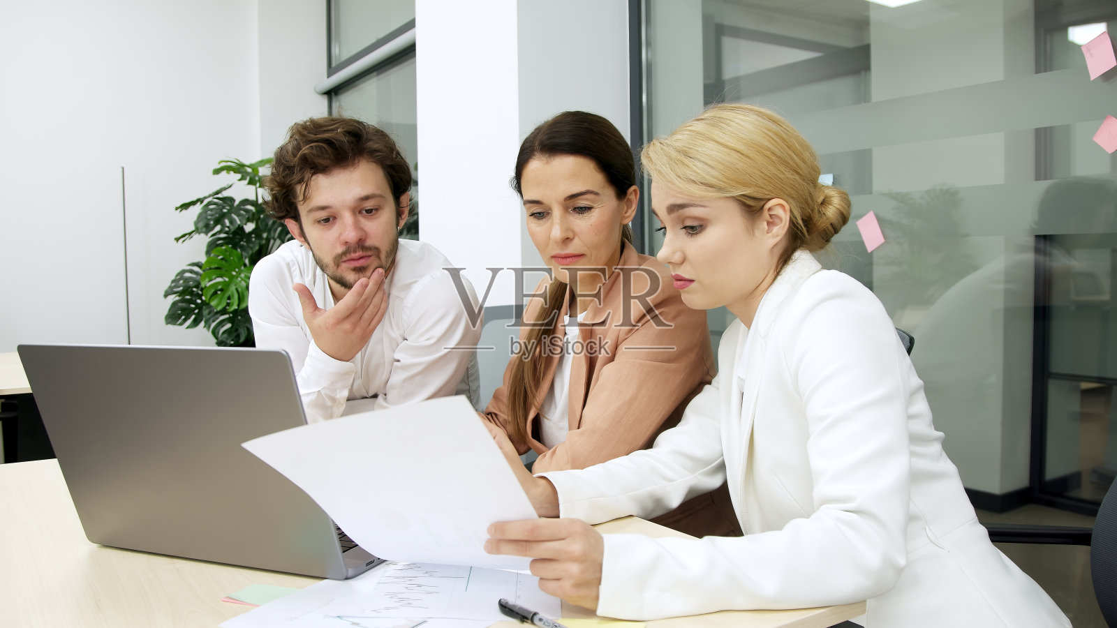 现代办公室的业务团队使用笔记本电脑进行财务分析。他们头脑风暴,讨论一个公司项目,合作解决方案。非常适合团队合作和财务战略主题。照片摄影图片